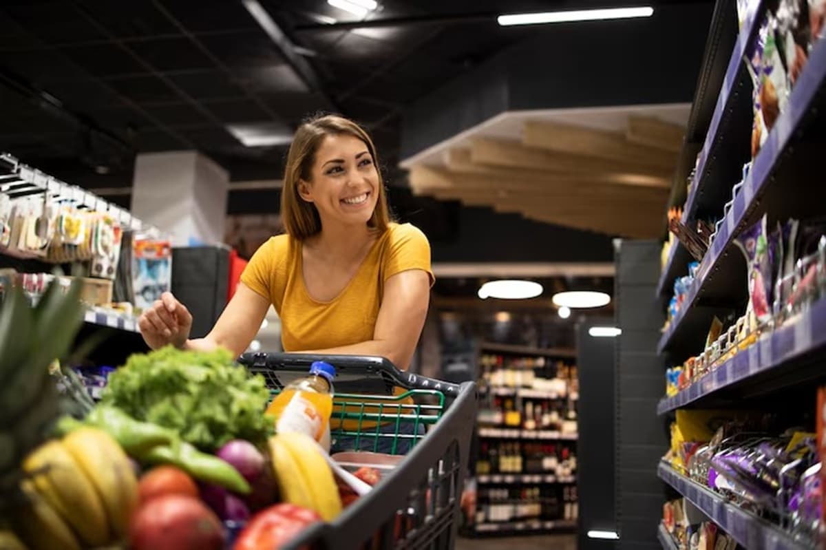 Interior de supermercado com prateleiras abastecidas e corredor vazio