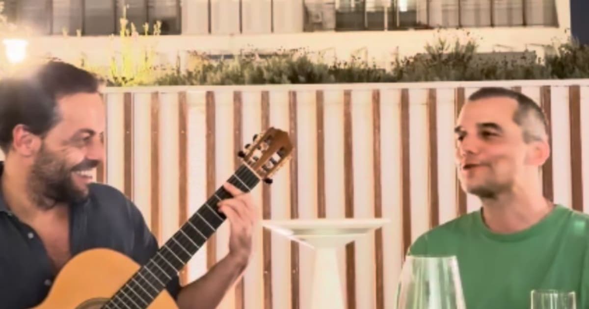 Wagner Moura em momento musical, cantando ao microfone
