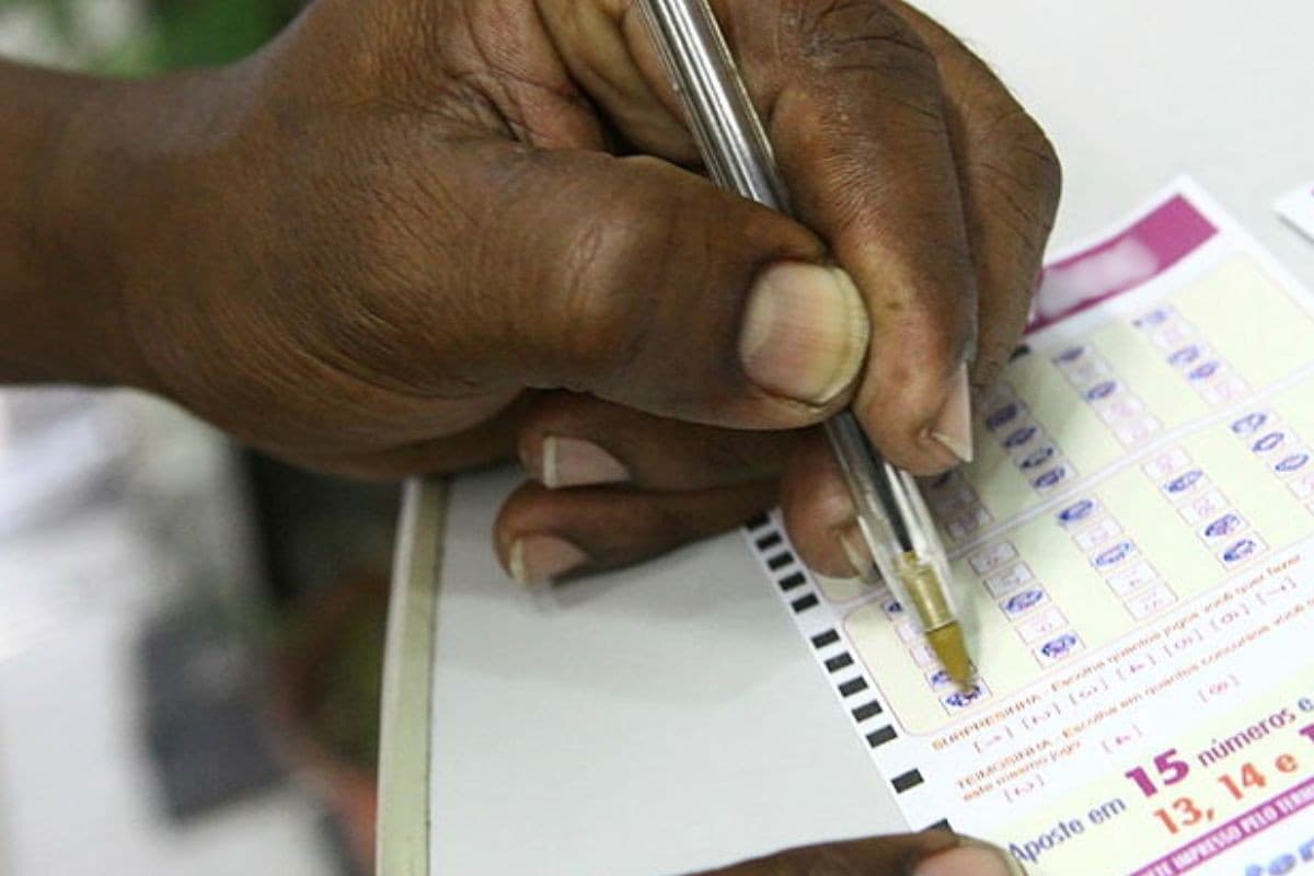 Bilhete de loteria sobre mesa, representando o golpe do bilhete premiado