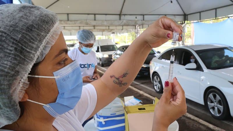 Posto de vacinação instalado dentro de shopping em Aracaju, com profissional de saúde atendendo a população