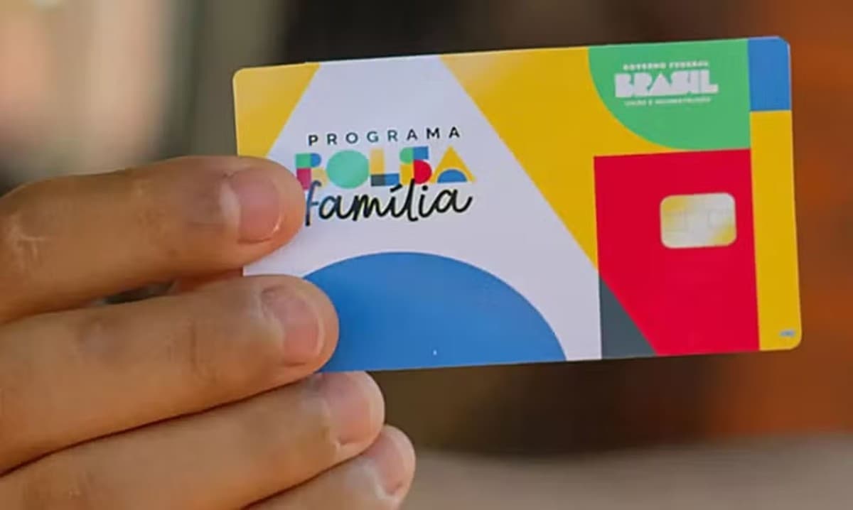 Cartão do Bolsa Família sobre mesa com documentos e caderneta de vacinação
