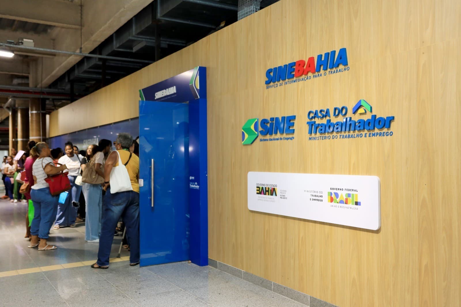 Fachada de unidade do SineBahia com candidatos aguardando atendimento