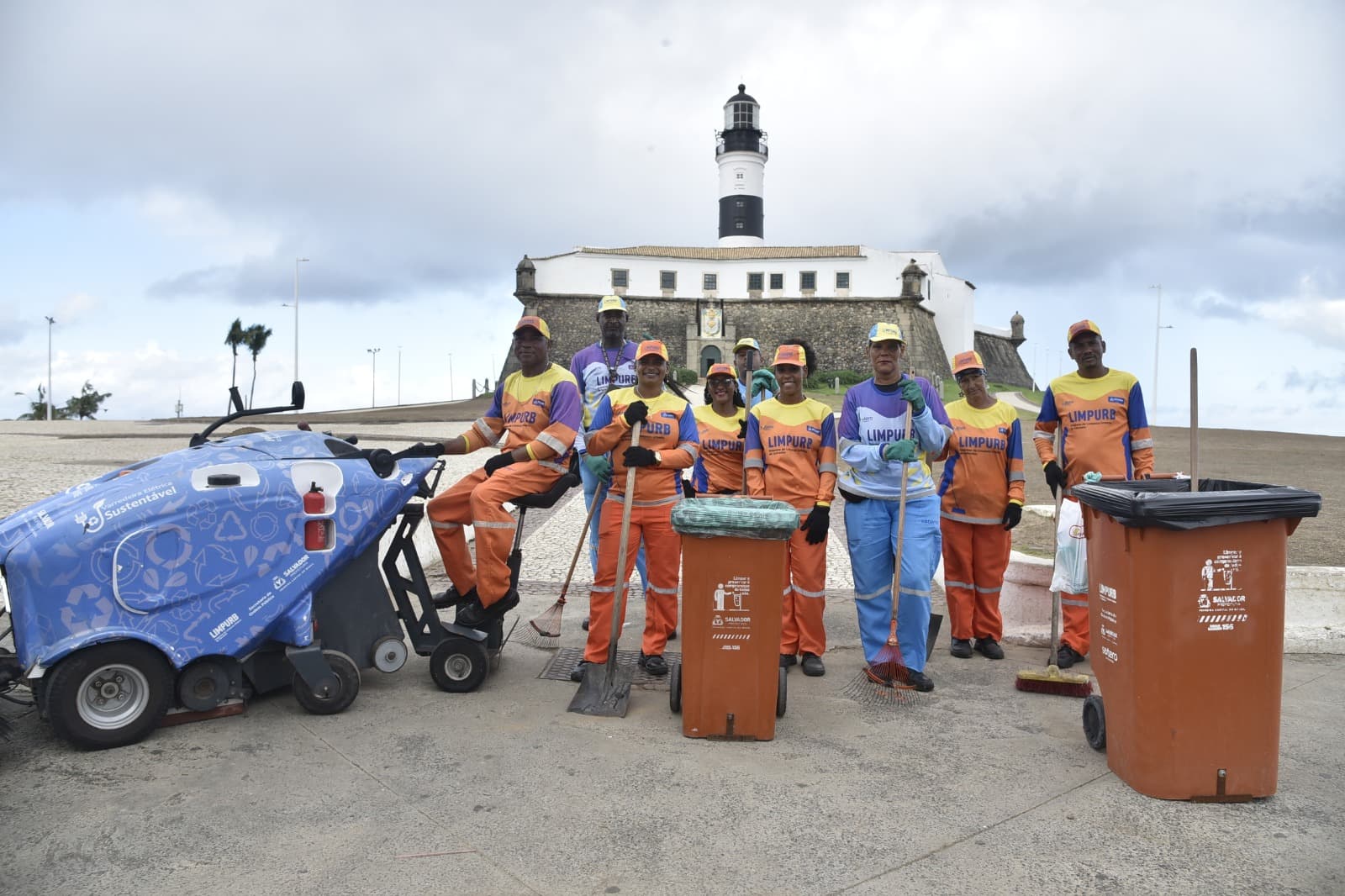 Caminhão de coleta de lixo nas ruas de Salvador com garis ao fundo