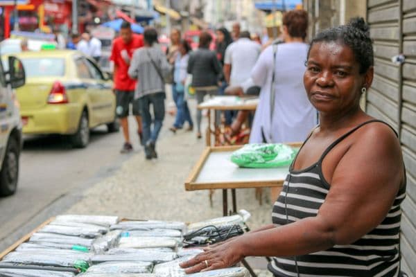 Mulher negra trabalhando em ambiente informal, representando vulnerabilidade socioeconômica
