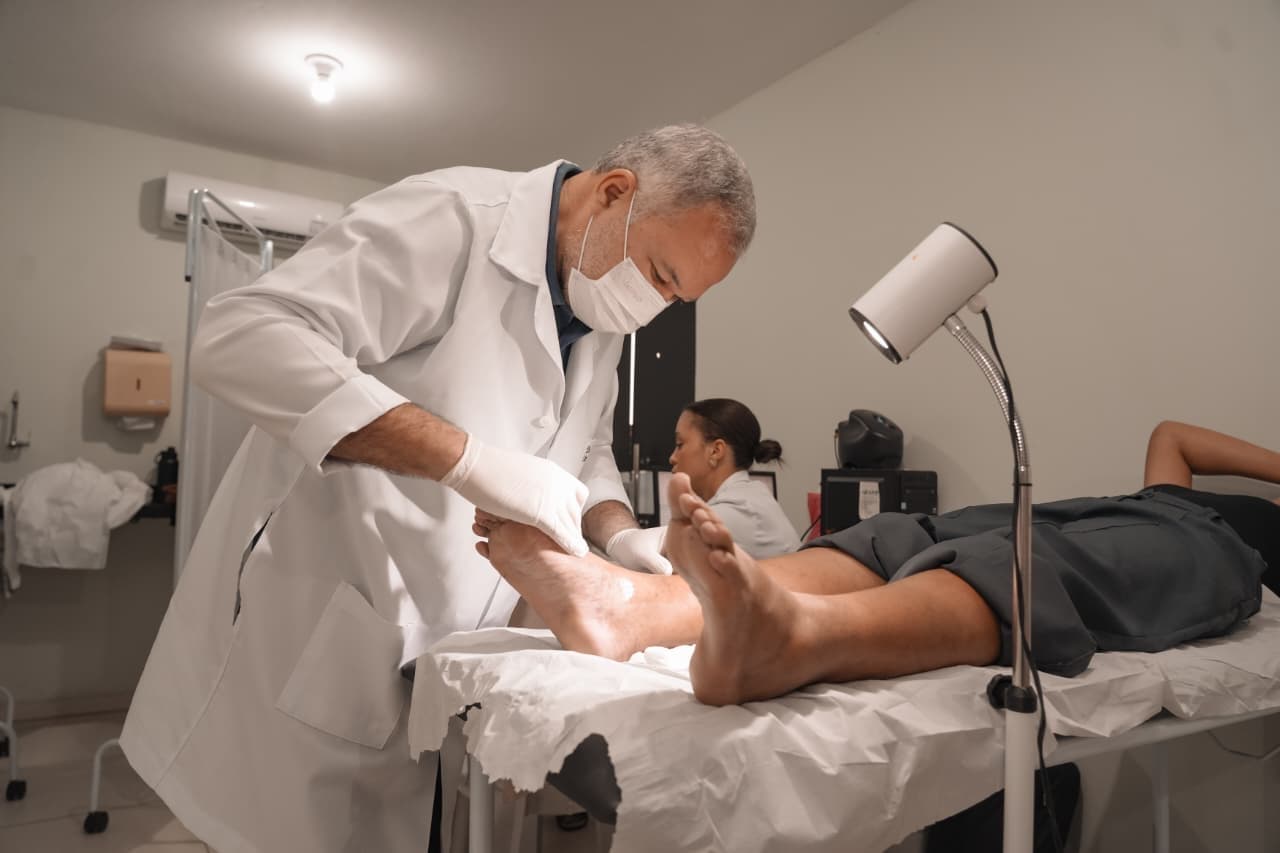 Profissional de saúde realizando aplicação de escleroterapia com espuma em paciente durante mutirão de varizes em Araripina