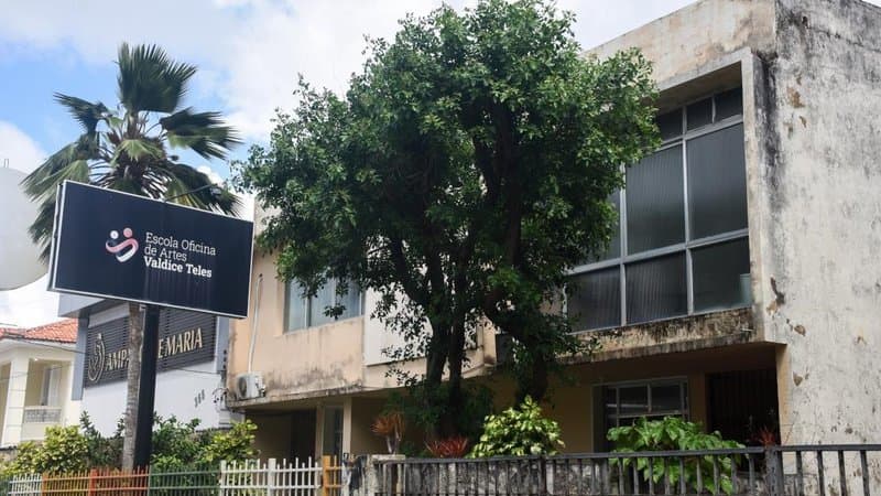 Fachada da Escola Oficina de Artes Valdice Teles em Aracaju, com alunos em atividade artística