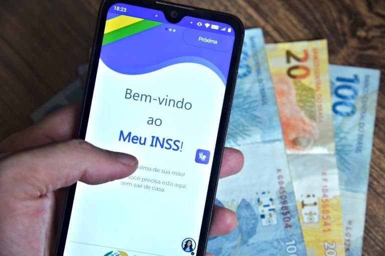 Idosa consulta aplicativo do celular para verificar pagamento do INSS