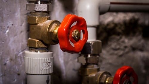 Trabalhador realizando instalação hidráulica predial em obra