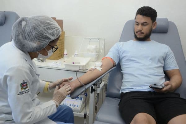 Profissional de saúde realiza coleta de sangue em doador voluntário em posto do Hemoal