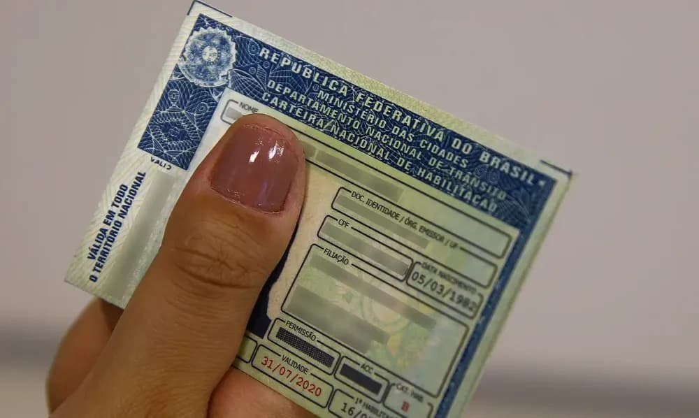 Carteira Nacional de Habilitação sobre mesa com documentos de trânsito
