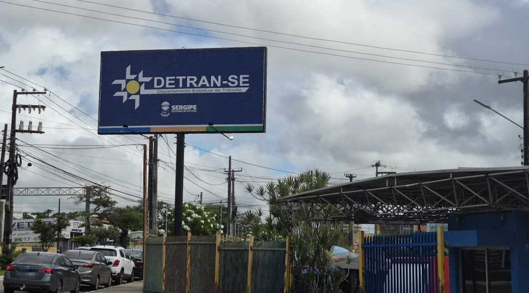 Pessoa entregando documentos em balcão do Detran para habilitação