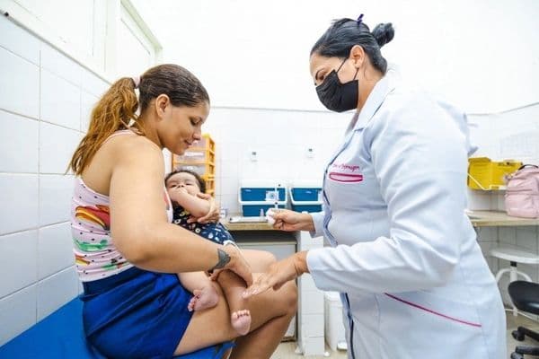 Criança sendo vacinada em unidade de saúde do SUS com a vacina Pneumo 20