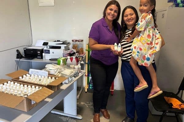 Crianças em creche pública sendo atendidas por equipe de saúde em atividade preventiva