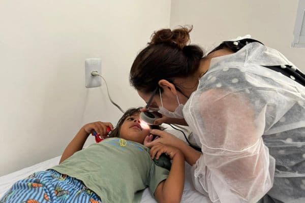 Médica examinando a pele de uma criança em consultório pediátrico