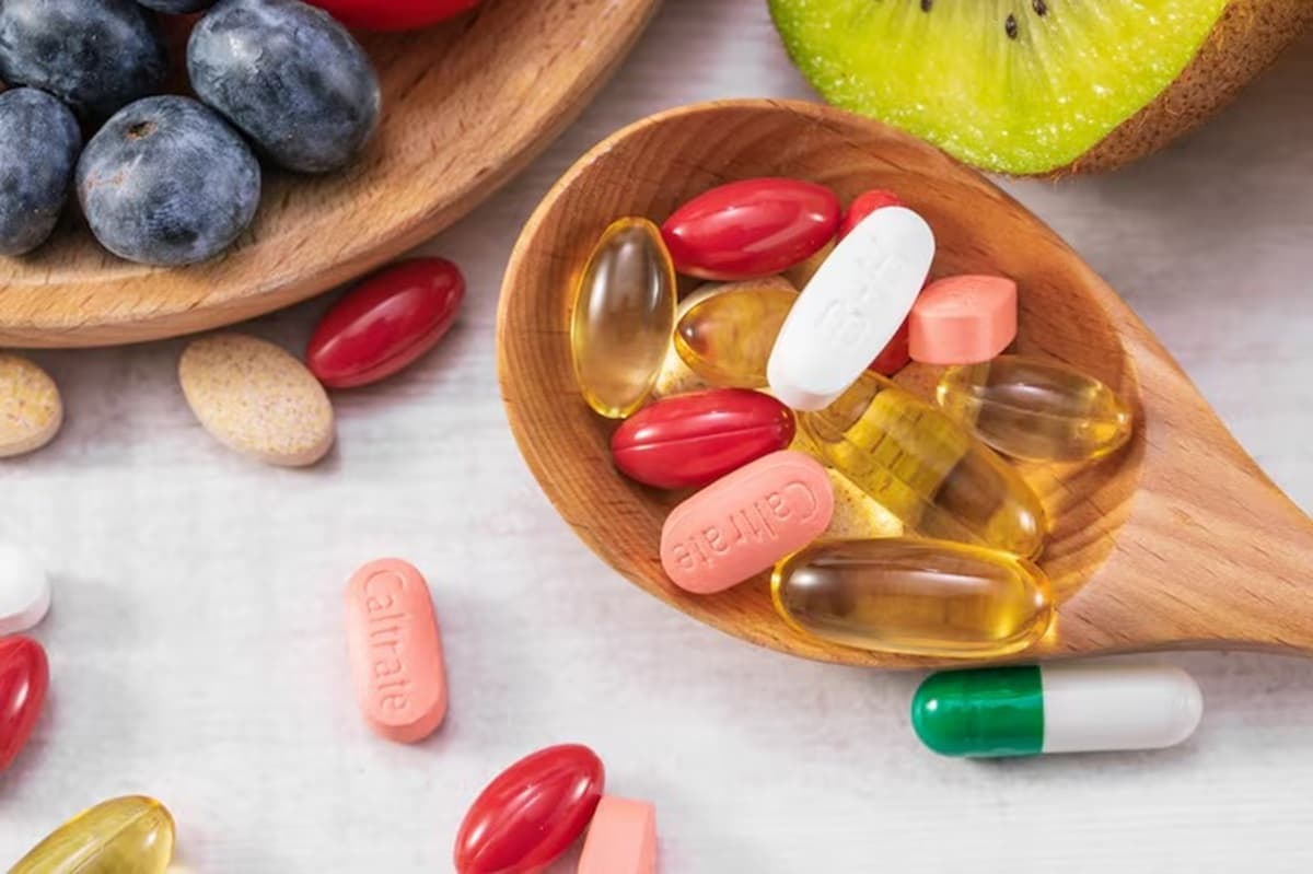 Frascos de suplementos alimentares em cápsulas sobre balcão, representando produtos fiscalizados pela Anvisa