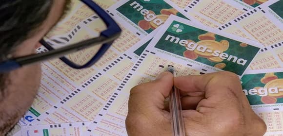 Volante da Mega-Sena com números marcados sobre fundo verde