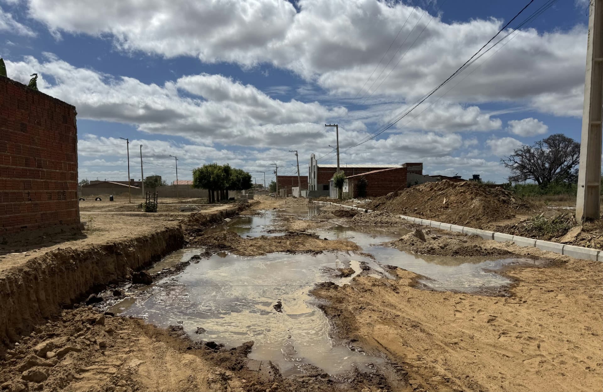 Rua com água escorrendo após rompimento de encanação no Loteamento Rocha, em Cabrobó (PE)