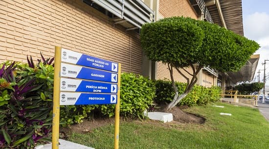 Candidatos entregando documentos em repartição pública para processo de admissão em concurso