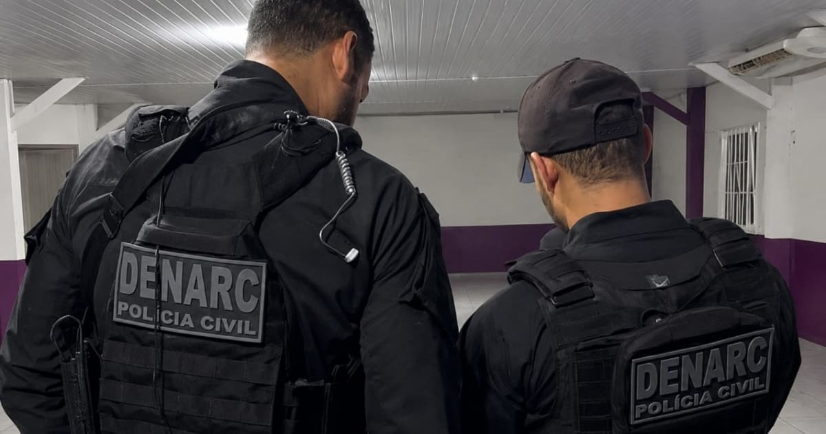 Policiais durante operação de combate ao tráfico de drogas com material apreendido sobre mesa