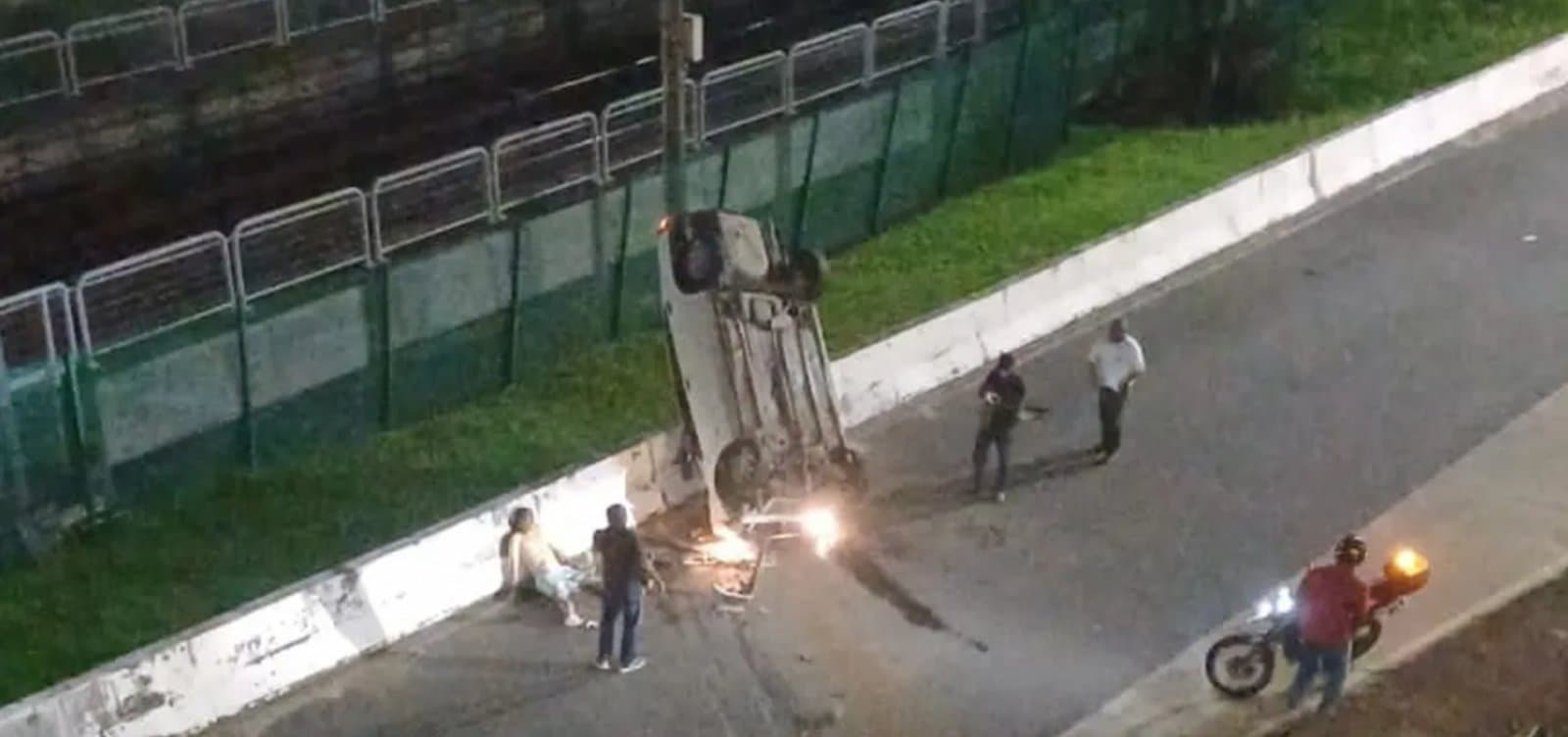 Carro tombado de cabeça para baixo próximo aos trilhos do metrô após cair de viaduto em Salvador