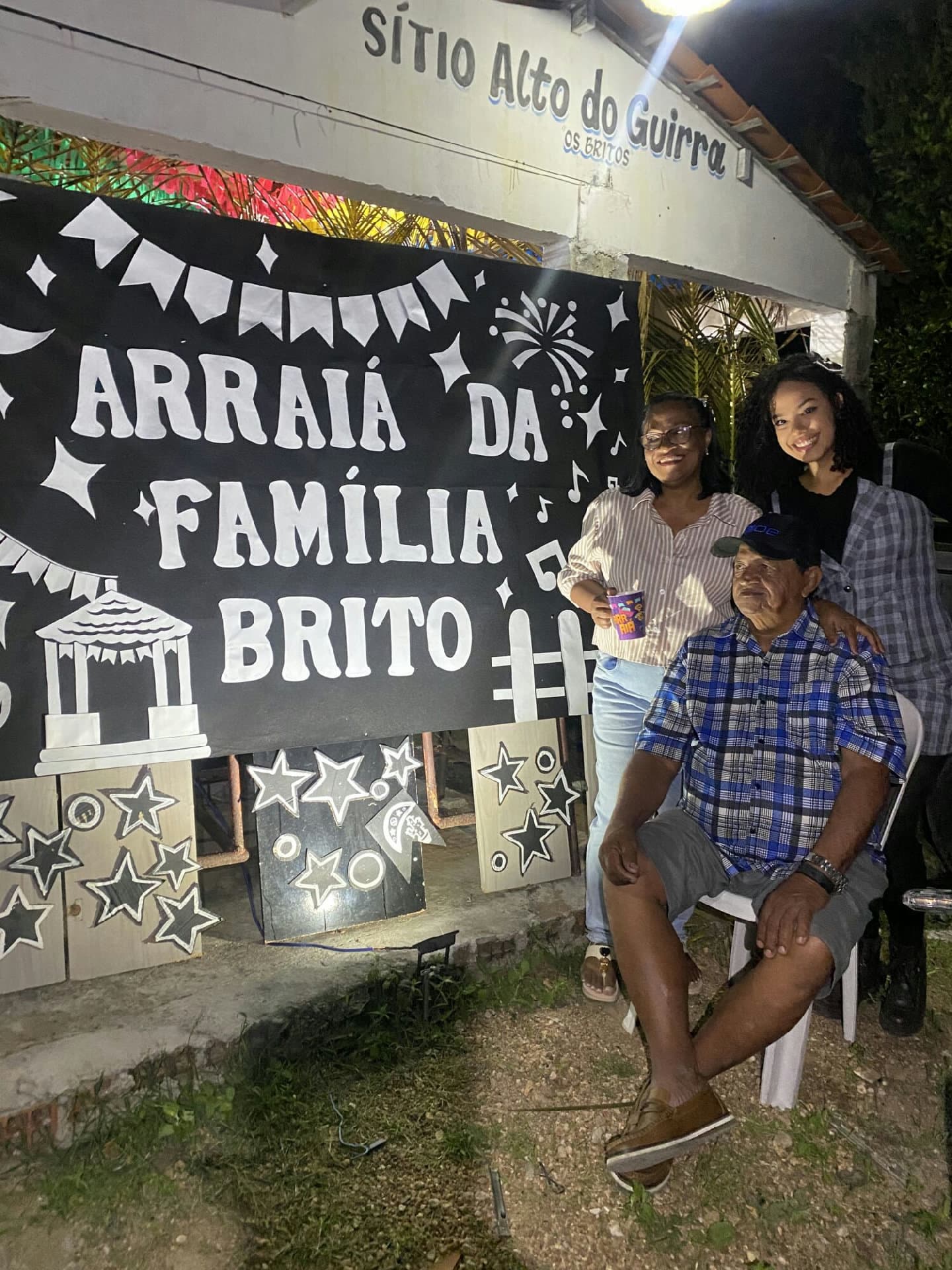 Família reunida ao redor de fogueira junina no sertão alagoano, com decorações típicas de São João
