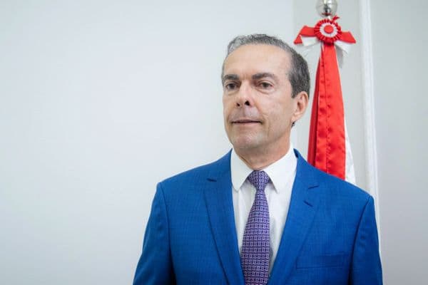 Jornalista diante de pilha de documentos judiciais, simbolizando o assédio judicial contra a imprensa no Brasil