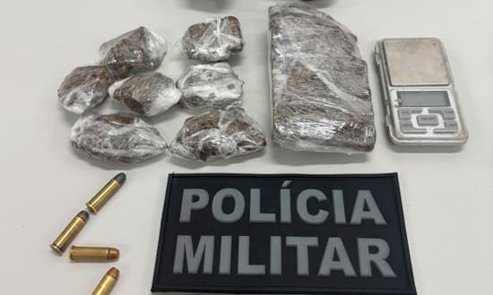 Policial militar do BPRp ao lado de material apreendido: revólver, porções de maconha e balança digital