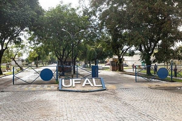 Trabalhador realizando pequeno reparo em edificação de campus universitário