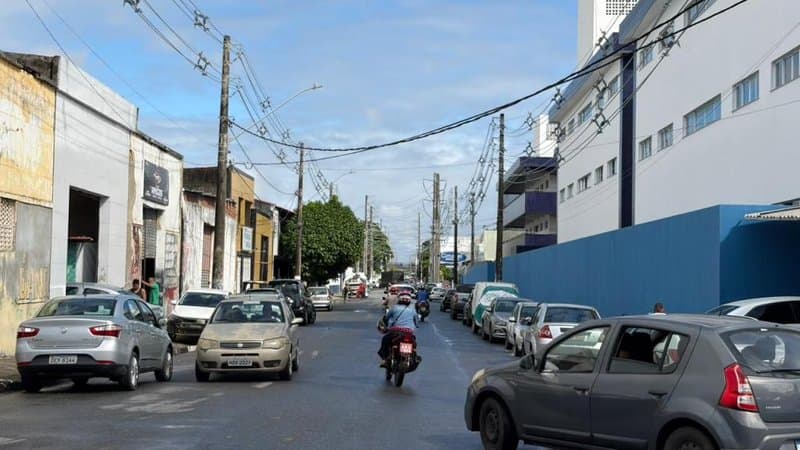 Obras de macrodrenagem em via urbana de Aracaju com agentes de trânsito orientando condutores