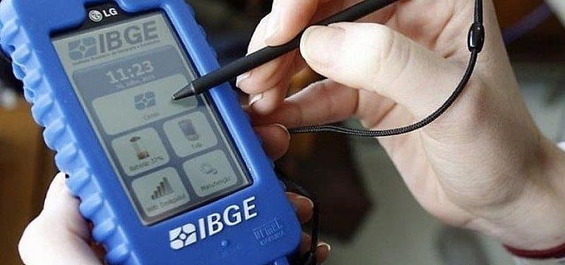 Pesquisador do IBGE com tablet em área rural durante levantamento de dados do Censo Agropecuário