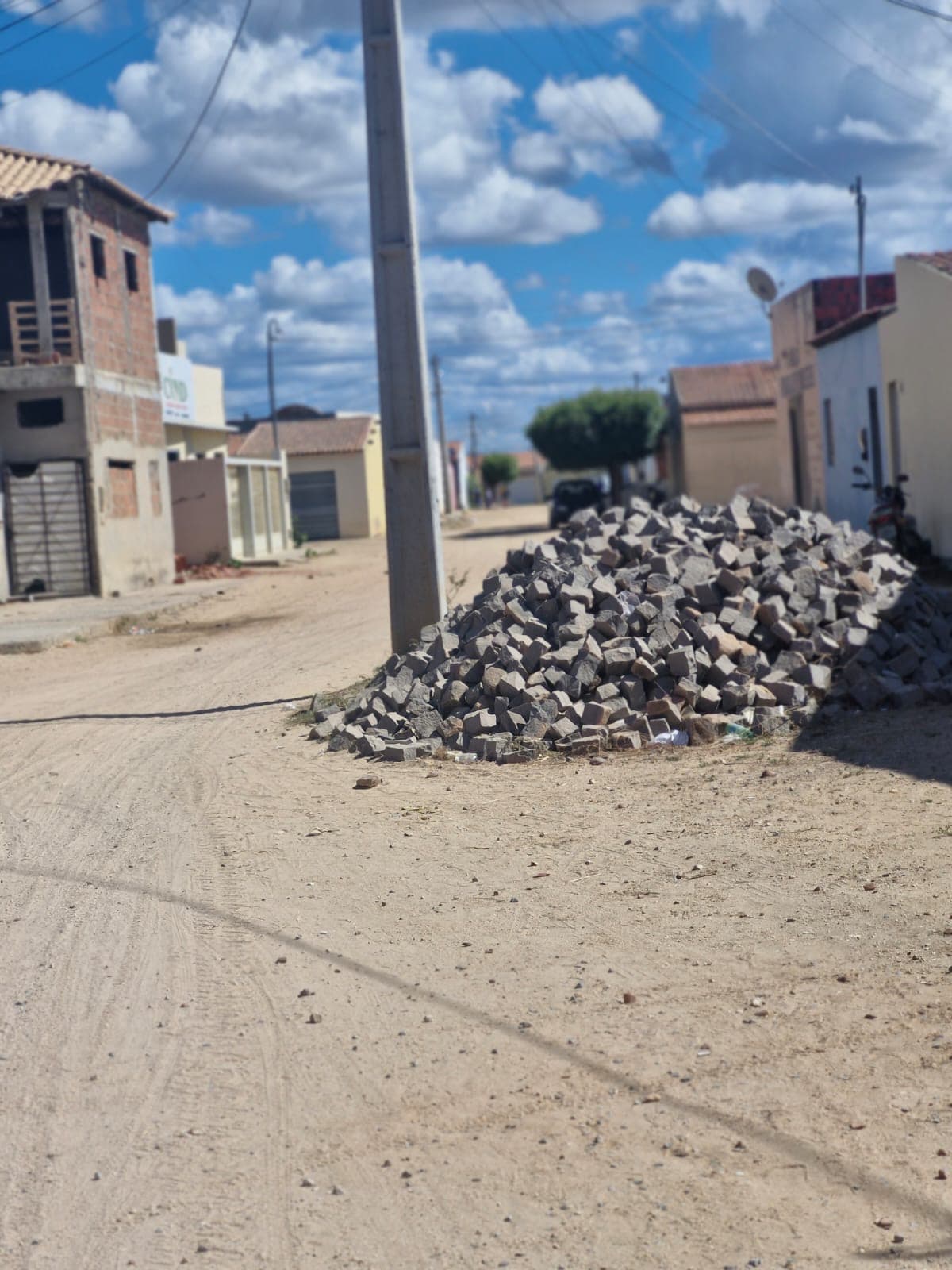 Poste de energia elétrica em meio a obra de calçamento em distrito baiano