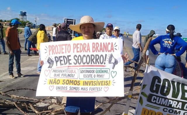Agricultores bloqueiam a BR-116 no Trevo dos Sem Terra em Abaré, Bahia, com faixas e cartazes pedindo energia elétrica para irrigação