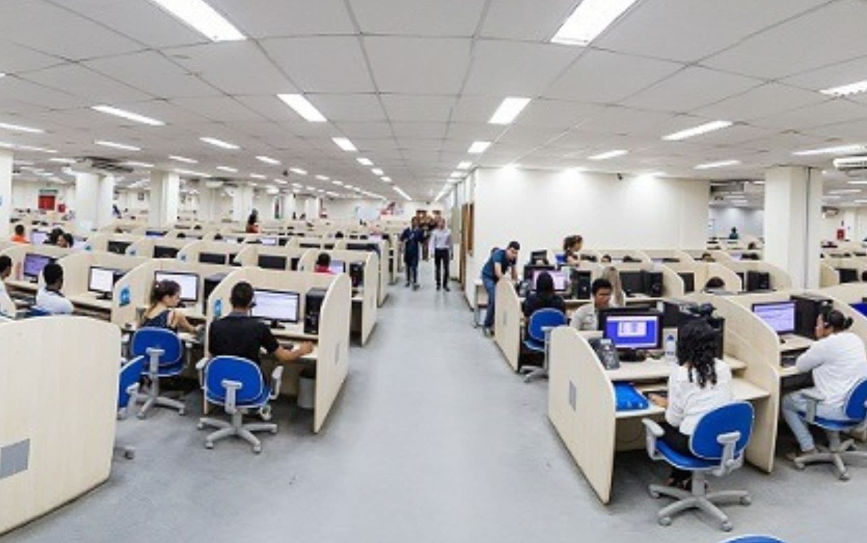 Atendente de telemarketing trabalhando com headset em central de atendimento
