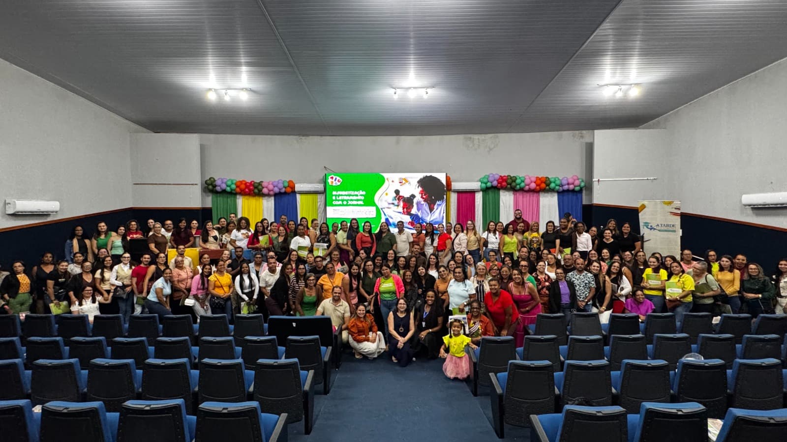 Professores sentados em auditório durante formação sobre letramento e alfabetização em Rio Real, Bahia