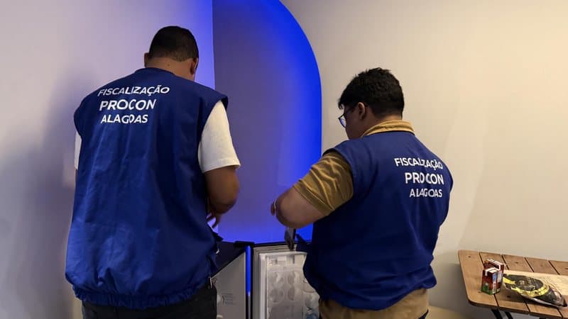 Fiscal do Procon verificando produtos em prateleira de motel durante operação de fiscalização