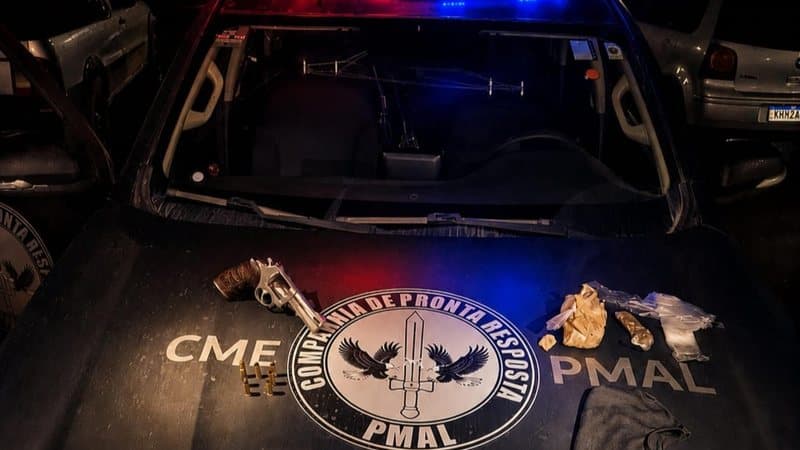 Material apreendido pela PM em São Miguel dos Milagres: revólver, drogas e mochila preta sobre superfície