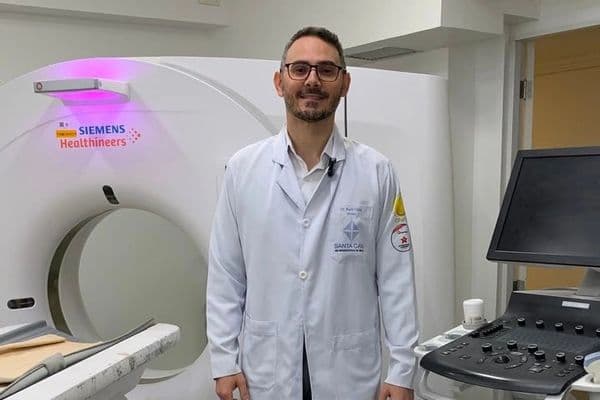 Médico realiza biópsia guiada por imagem com auxílio de monitor de ultrassom