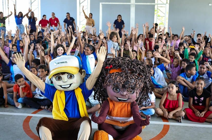 Crianças recebendo kit pedagógico de educação para o trânsito em escola pública de Alagoas