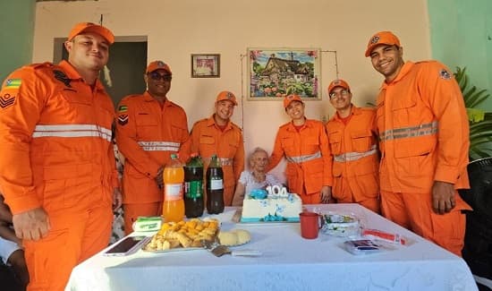 Militares do Corpo de Bombeiros de Sergipe posam ao lado de idosa centenária durante festa de aniversário