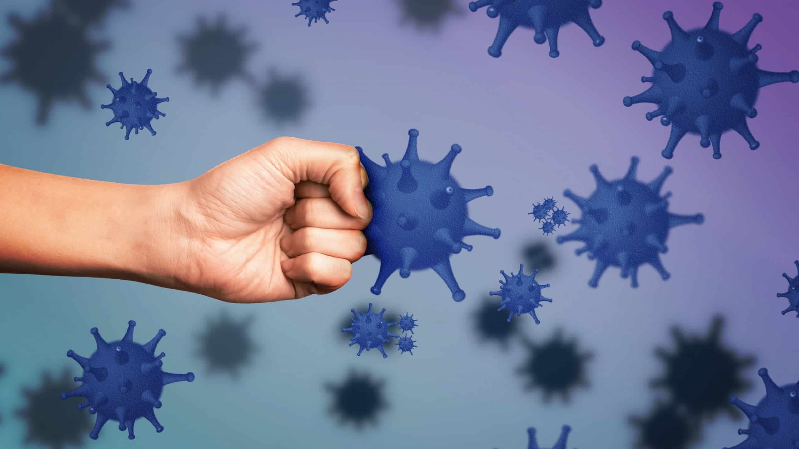 Homem exibindo punho cerrado cercado por vírus, simbolizando o fortalecimento da imunidade contra doenças / Crédito: New Africa (Shutterstock/reprodução)