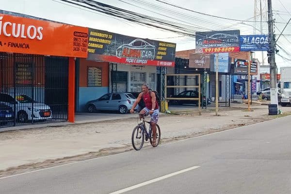 Ciclista dividindo espaço com carros na Avenida Menino Marcelo, em Maceió