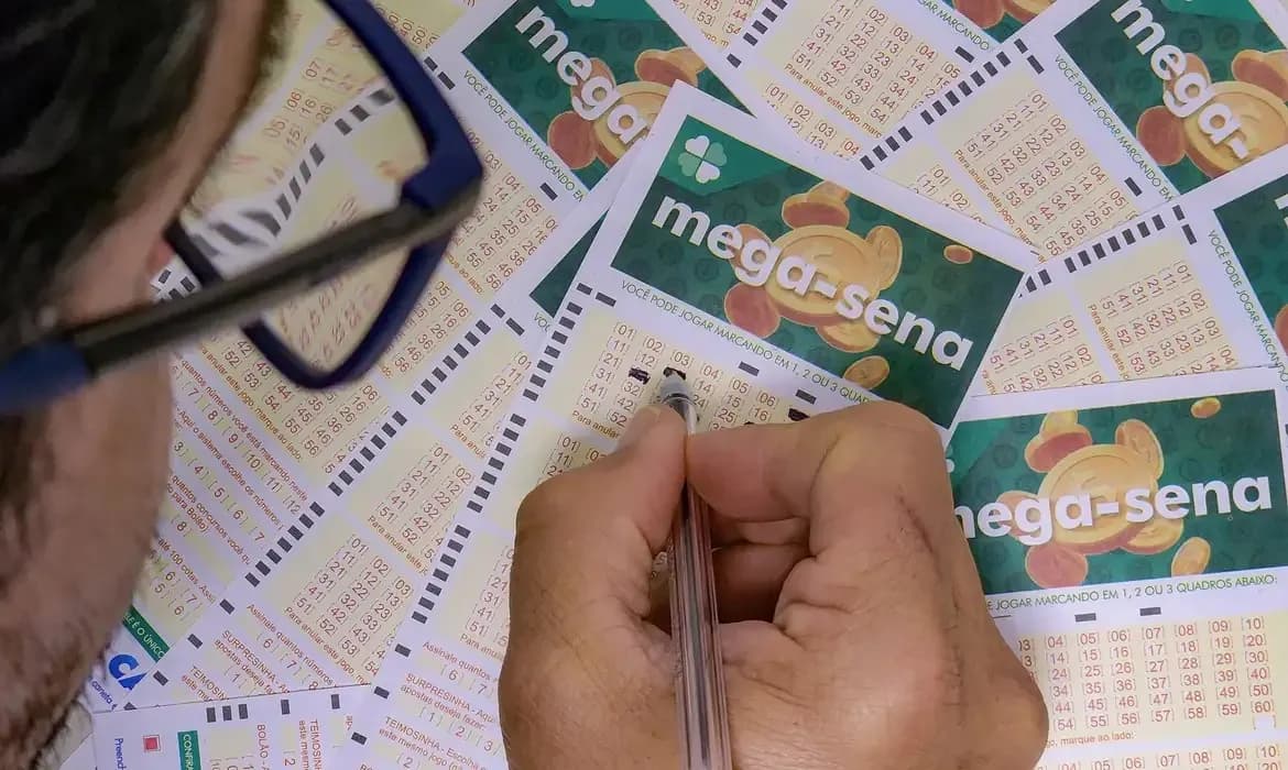 Volante da Mega-Sena com dezenas marcadas sobre mesa de lotérica