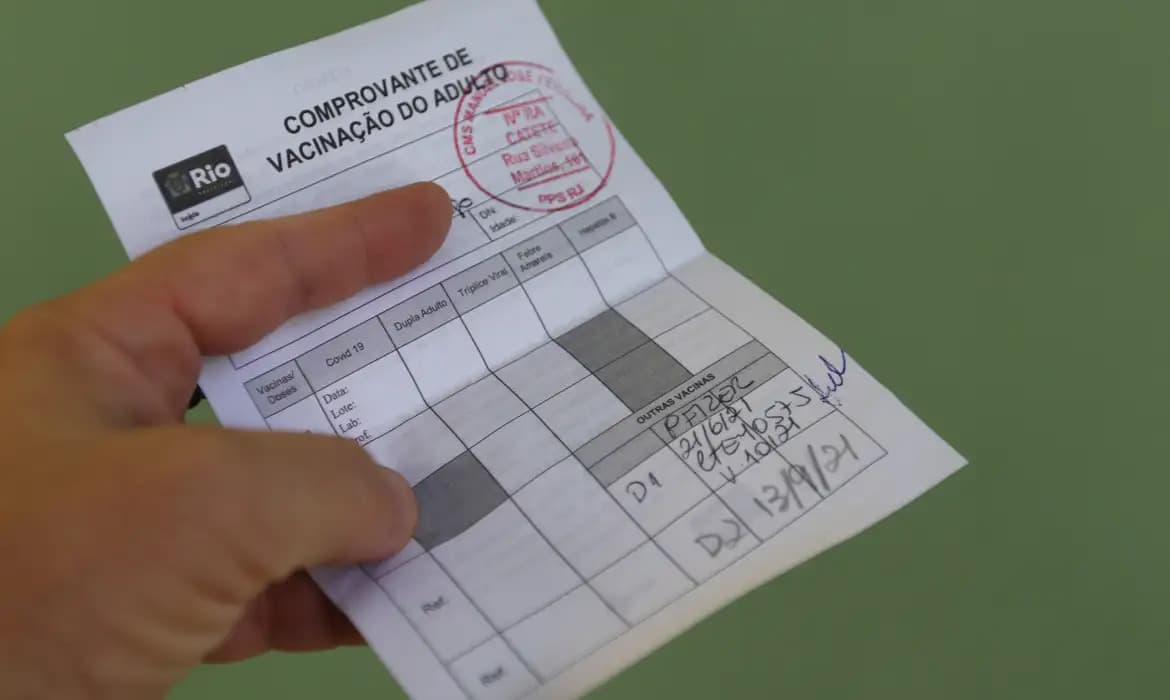 Mãos segurando smartphone com o aplicativo Telegram aberto, simbolizando a venda de passaportes vacinais falsos em grupos da plataforma