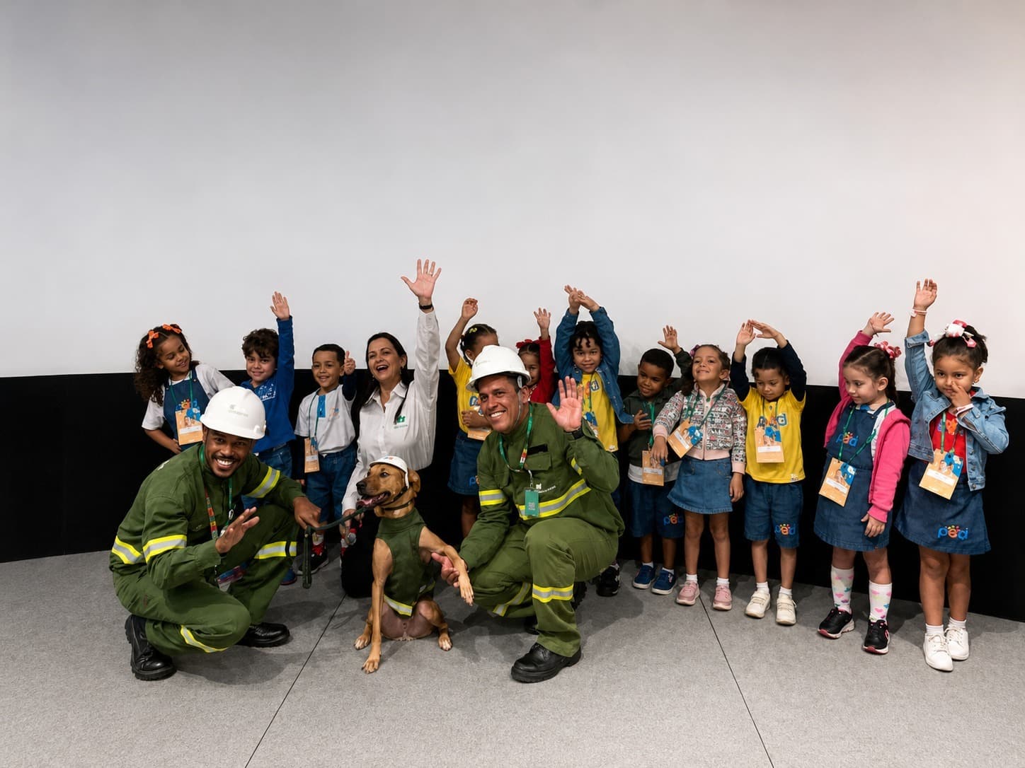 Cão vira-lata caramelo Max ao lado de eletricista da Neoenergia Coelba em ação educativa sobre segurança elétrica