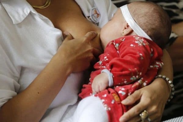 Mãe amamentando bebê recém-nascido em ambiente hospitalar