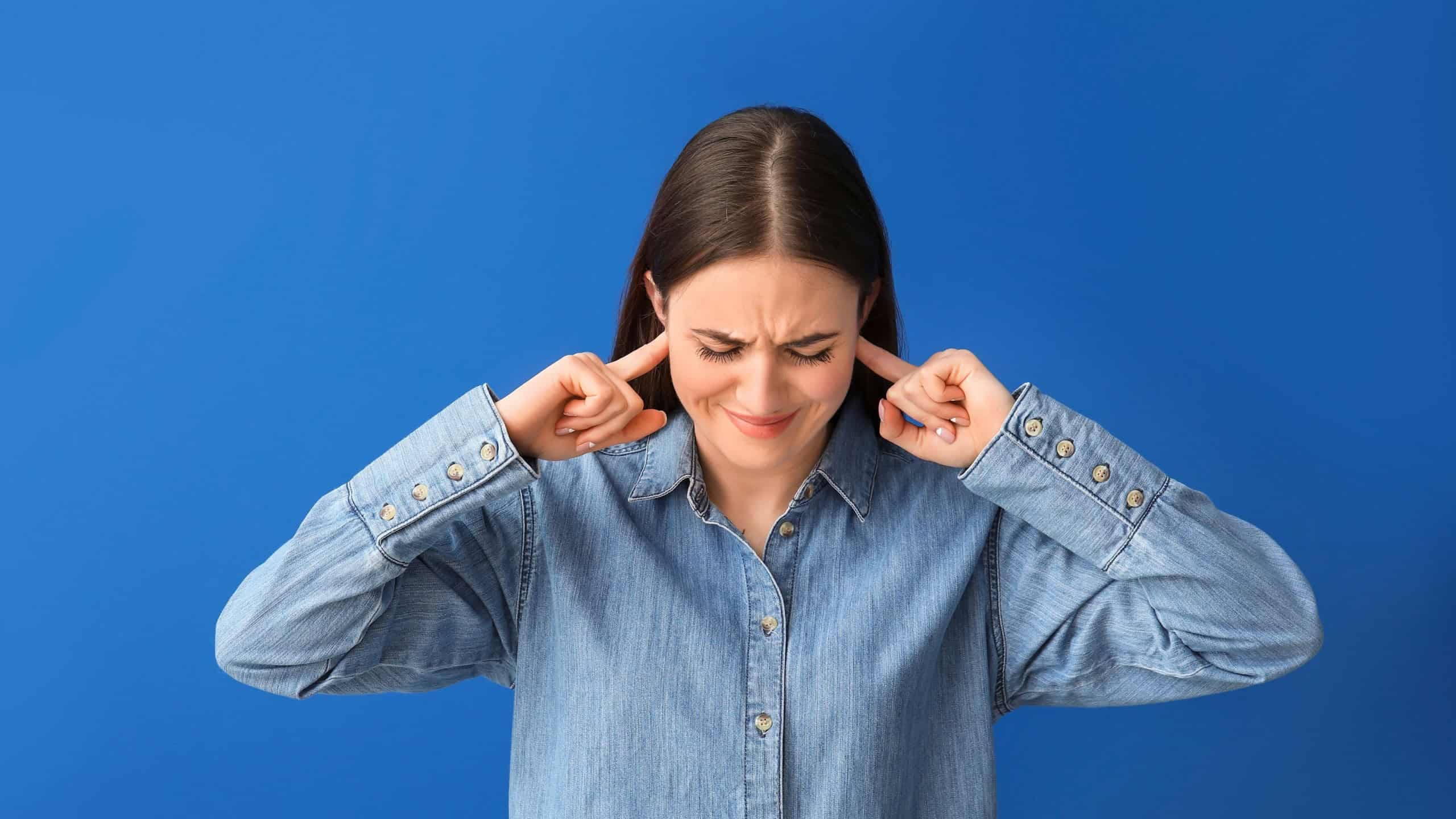 Mulher sofrendo com zumbido / Crédito: Pixel-shot (shutterstock/reprodução)