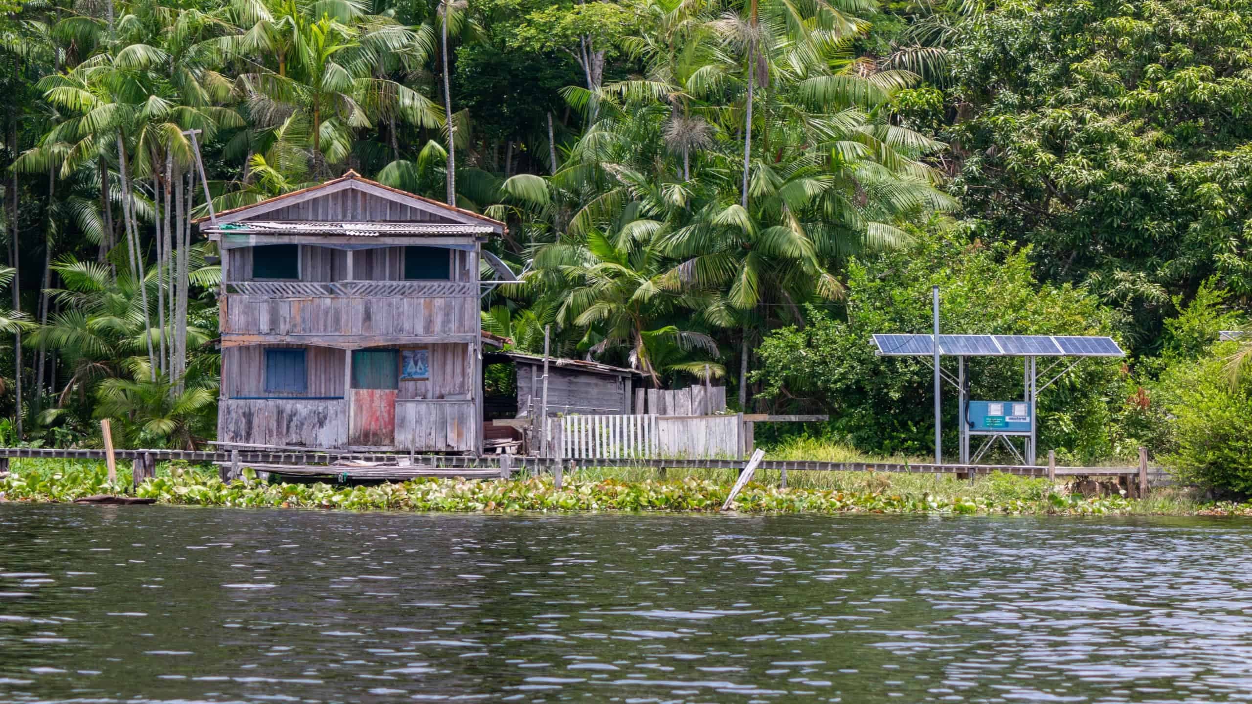 Comunidade ribeirinha na Amazônia utilizando energia solar, símbolo da transição energética discutida durante a COP30 em Belém (PA) (Imagem: Tarcisio Schnaider / Shutterstock.com)