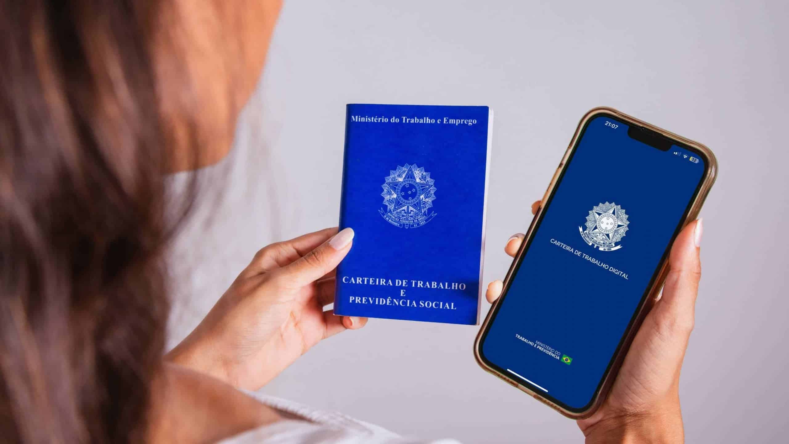 Mulher segurando uma carteira de trabalho e um celular com o aplicativo da carteira de trabalho(Imagem por Pedro Ignacio - Shutterstock)