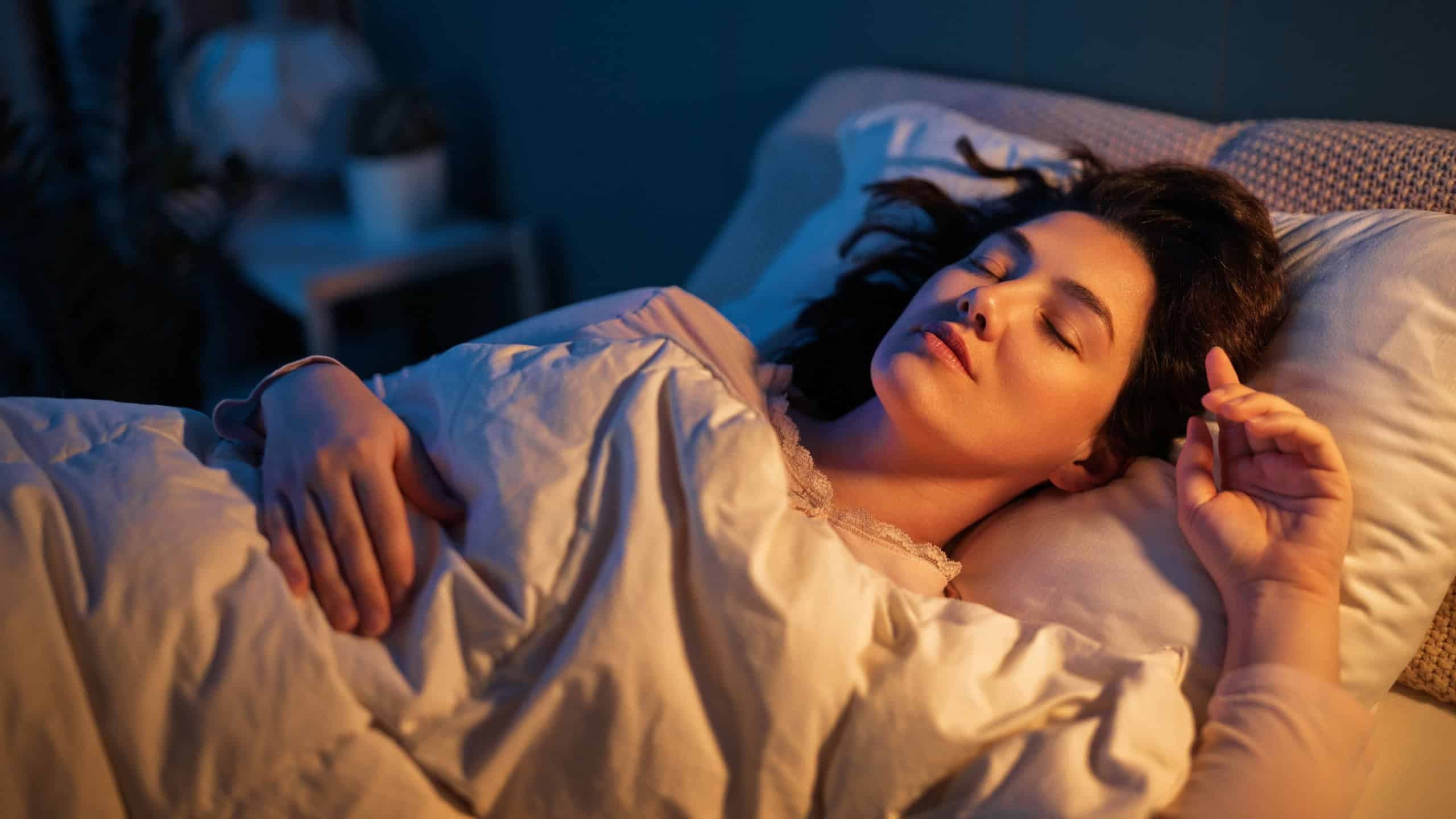 A mulher dorme em paz no quarto à noite. / Crédito: Yuganov Konstantin (shutterstock/reprodução)
