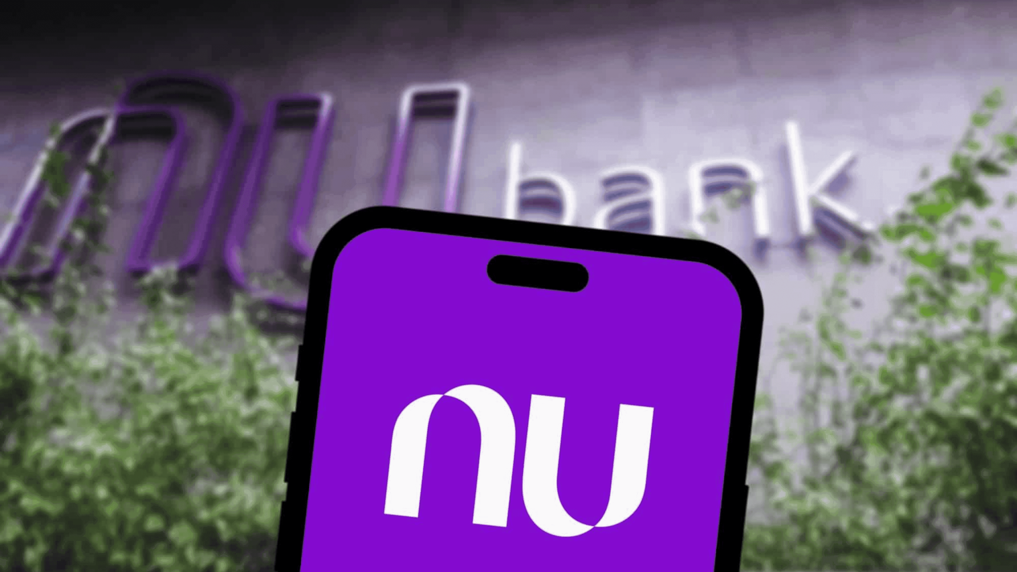 Aplicativo do Nubank e ao fundo a empresa - Imagem: QubixStudio / Shutterstock.com